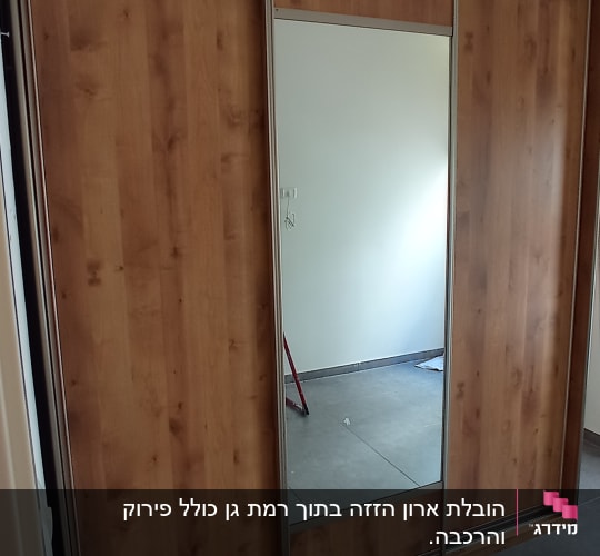 ארון עץ עם דלת מראה בחדר ריק